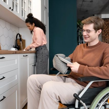 Two people washing dishes together in an accessible kitchen